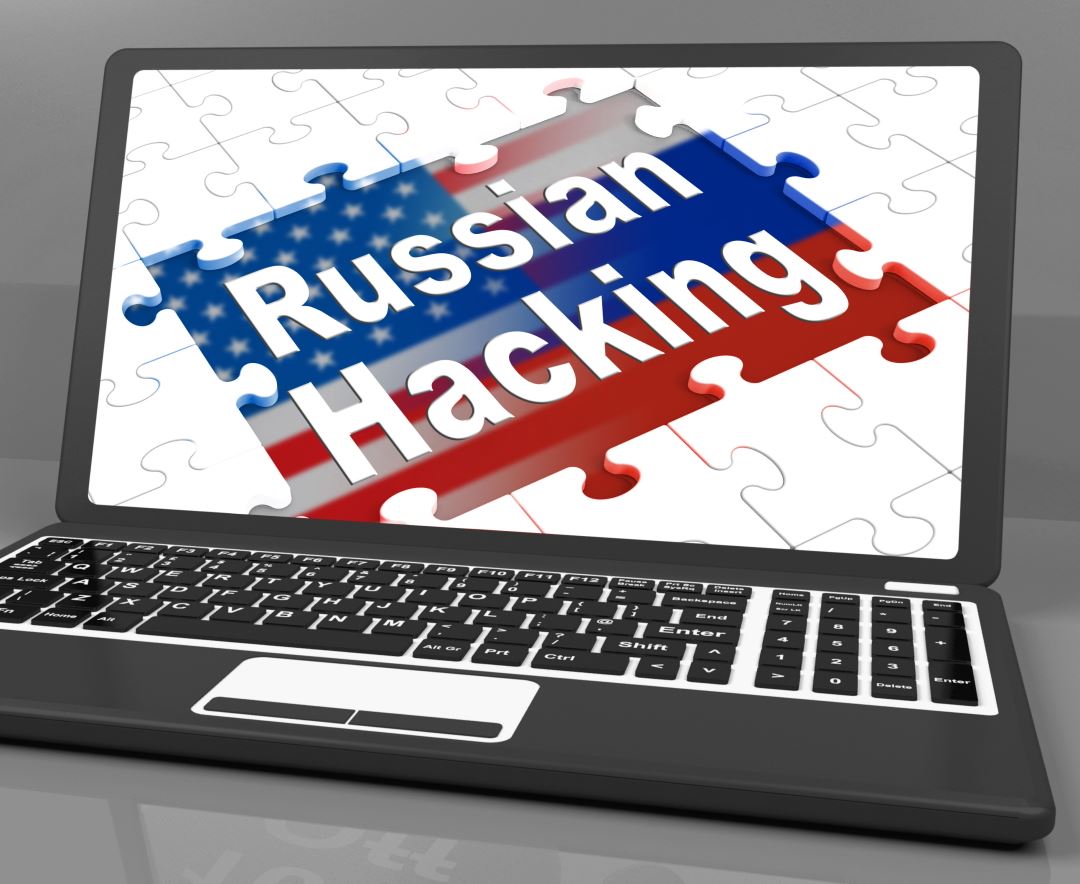 laptop computer with puzzel pieces and US flag with the words "Russian Hacking"